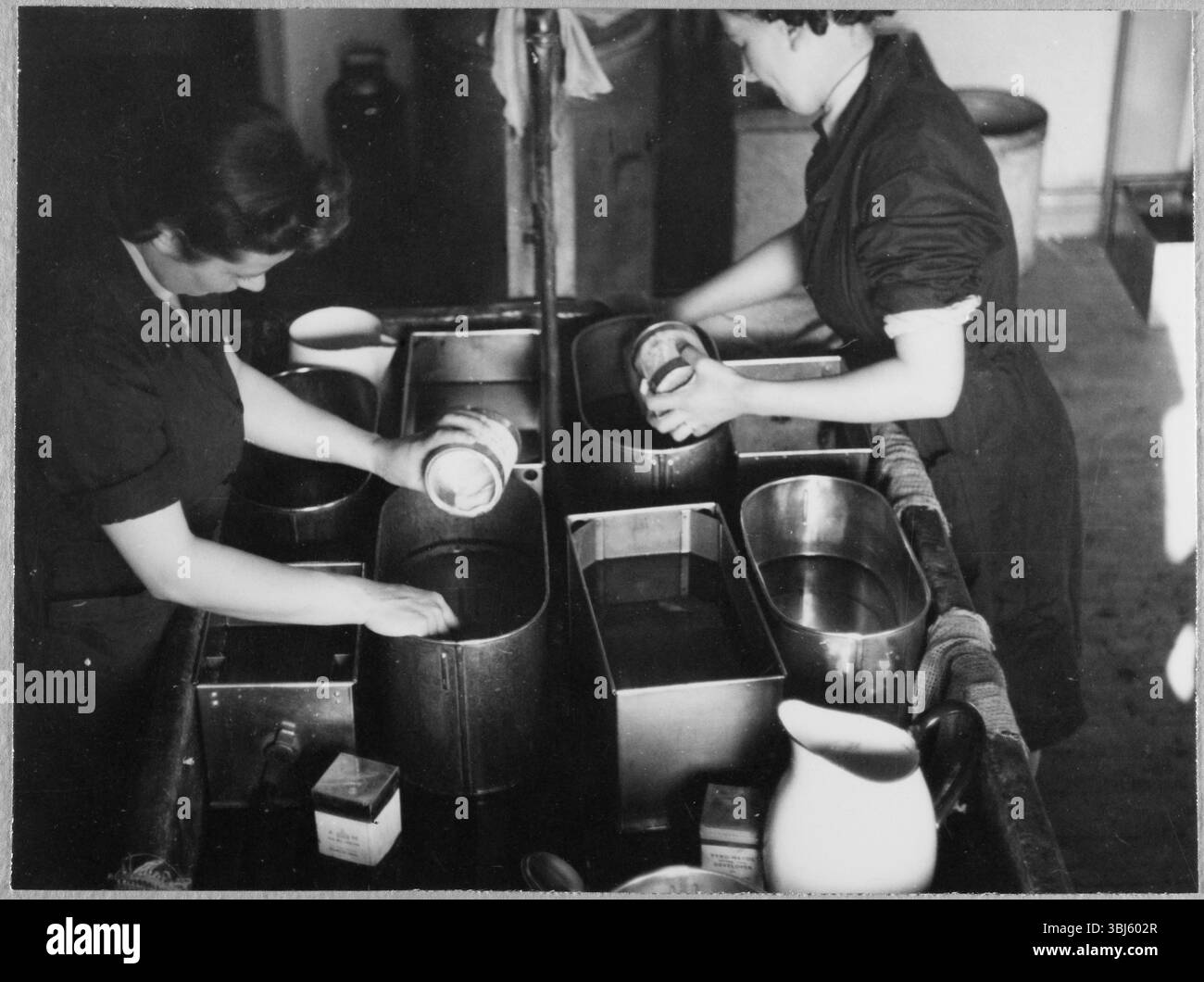 Royal Air Force No. 2 School of Photography, Palatine Road, Blackpool, Lancashire, 1942-1943. Tirocinanti dell'aeronautica ausiliaria femminile (WAAF) che mescolano sostanze chimiche per la lavorazione di pellicole fotografiche. La RAF’s No. 2 School of Photography è stata fondata nell'agosto 1940 per soddisfare la crescente esigenza di un numero sempre maggiore di fotografi e tecnici fotografici di aiutare con la ricognizione aerea durante la seconda guerra mondiale. La scuola aveva sede presso il Blackpool Technical College e la Palatine Secondary School di Blackpool. La formazione delle donne alla scuola iniziò nel 1941. Questa fotografia fa parte di un set scattato da Foto Stock