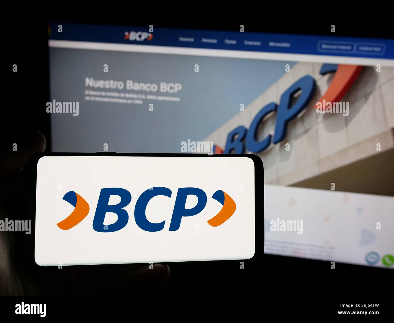 Stoccarda, Germania - 04-09-2025: Persona con smartphone con logo del Banco de credito de Bolivia S.A. (BCP) sullo schermo davanti al sito web. Foto Stock