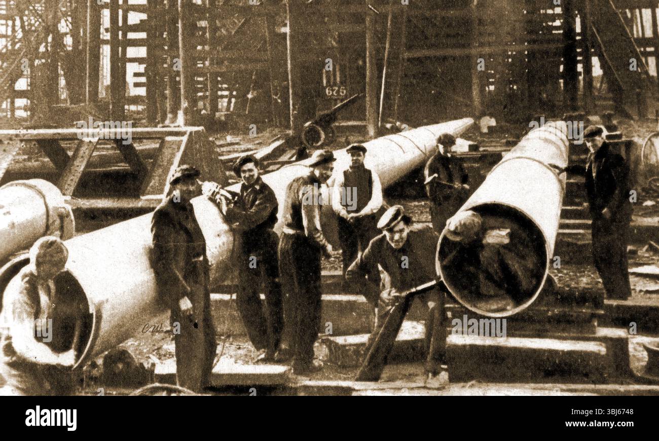 lavoratori portuali che posano tubi anni '1930 Foto Stock