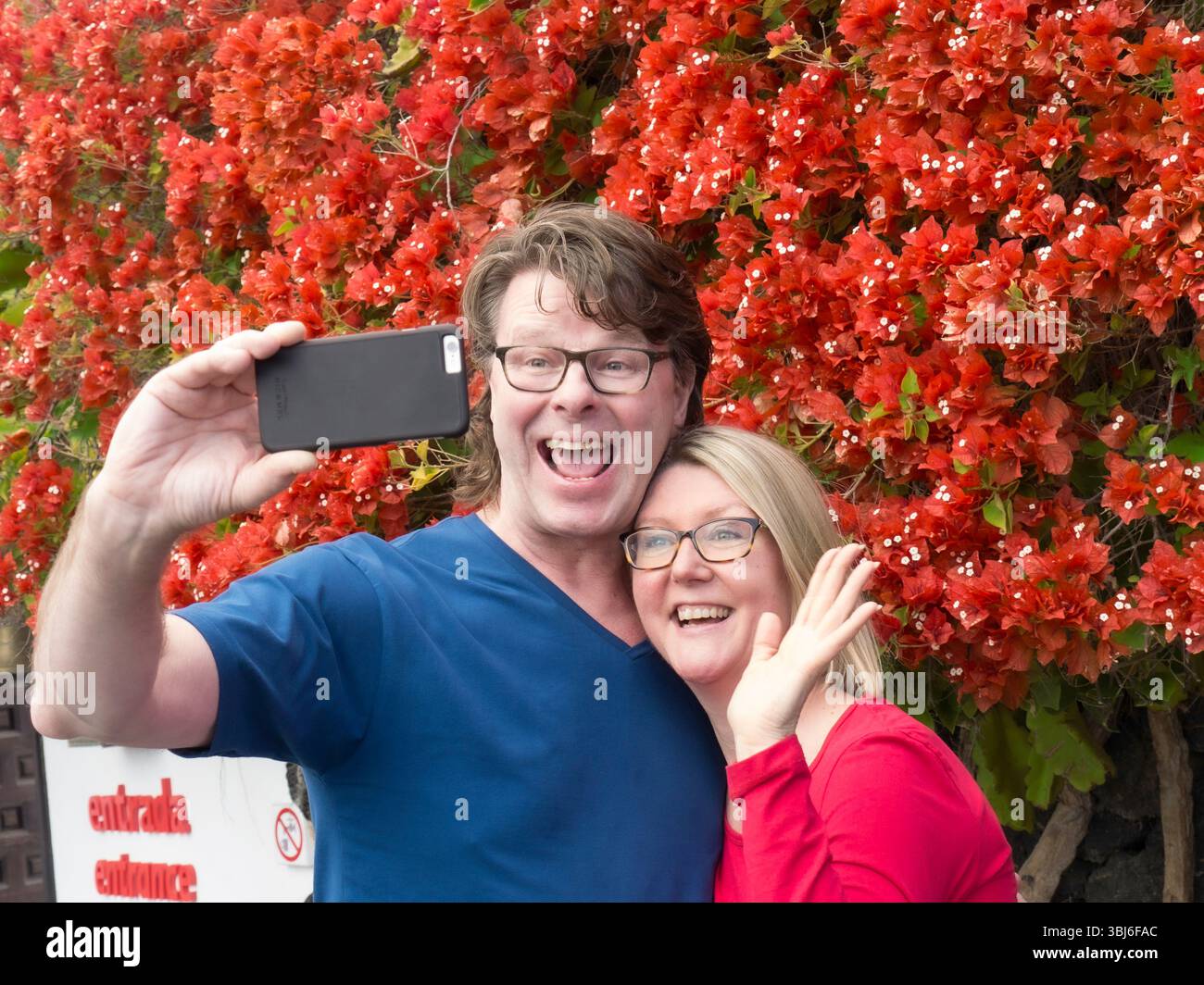 "SELFIE" coppia attraente che si diverte in vacanza scattando una foto "selfie" all'esterno dell'attrazione per le vacanze con l'applicazione fotocamera per smartphone iPhone Foto Stock