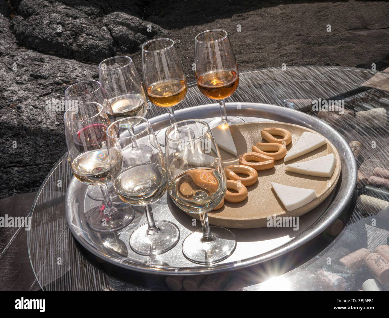 Degustazione DI VINI DI LANZAROTE all'aperto, selezione di vini rossi e bianchi, formaggi e biscotti, rocce vulcaniche lava picon. Lanzarote Isole Canarie la Spagna Foto Stock