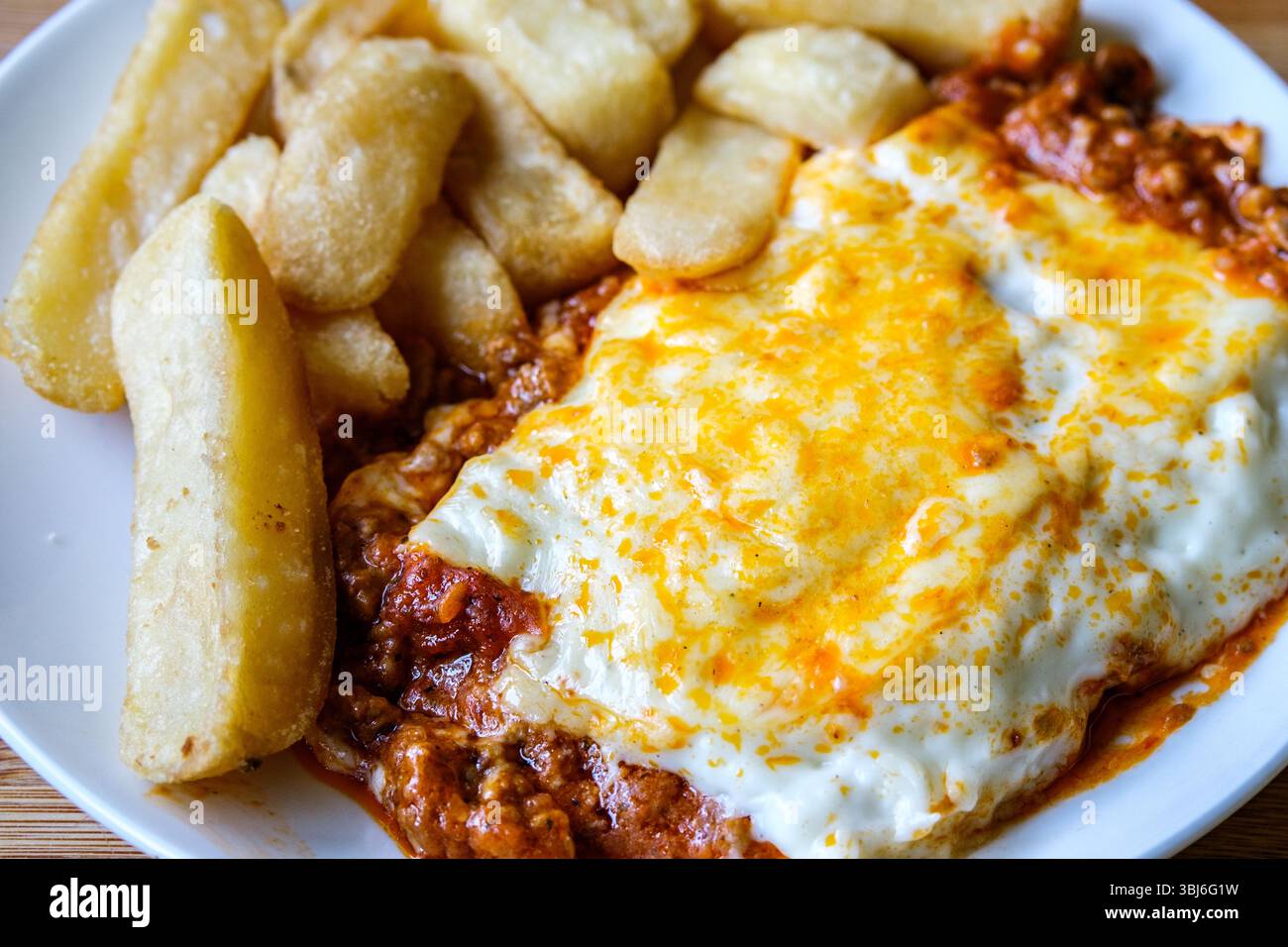 London UK, 13 giugno 2025, Classic Meat of Italian Style Beef Lasagne with Chips Foto Stock