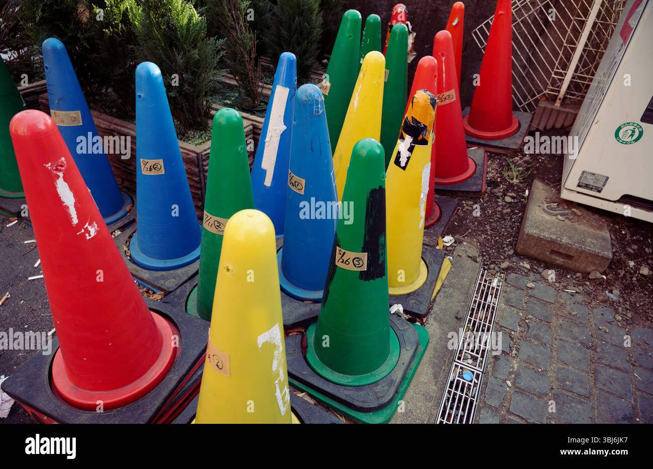 Un gruppo di coni stradali multicolori e intemprati Foto Stock