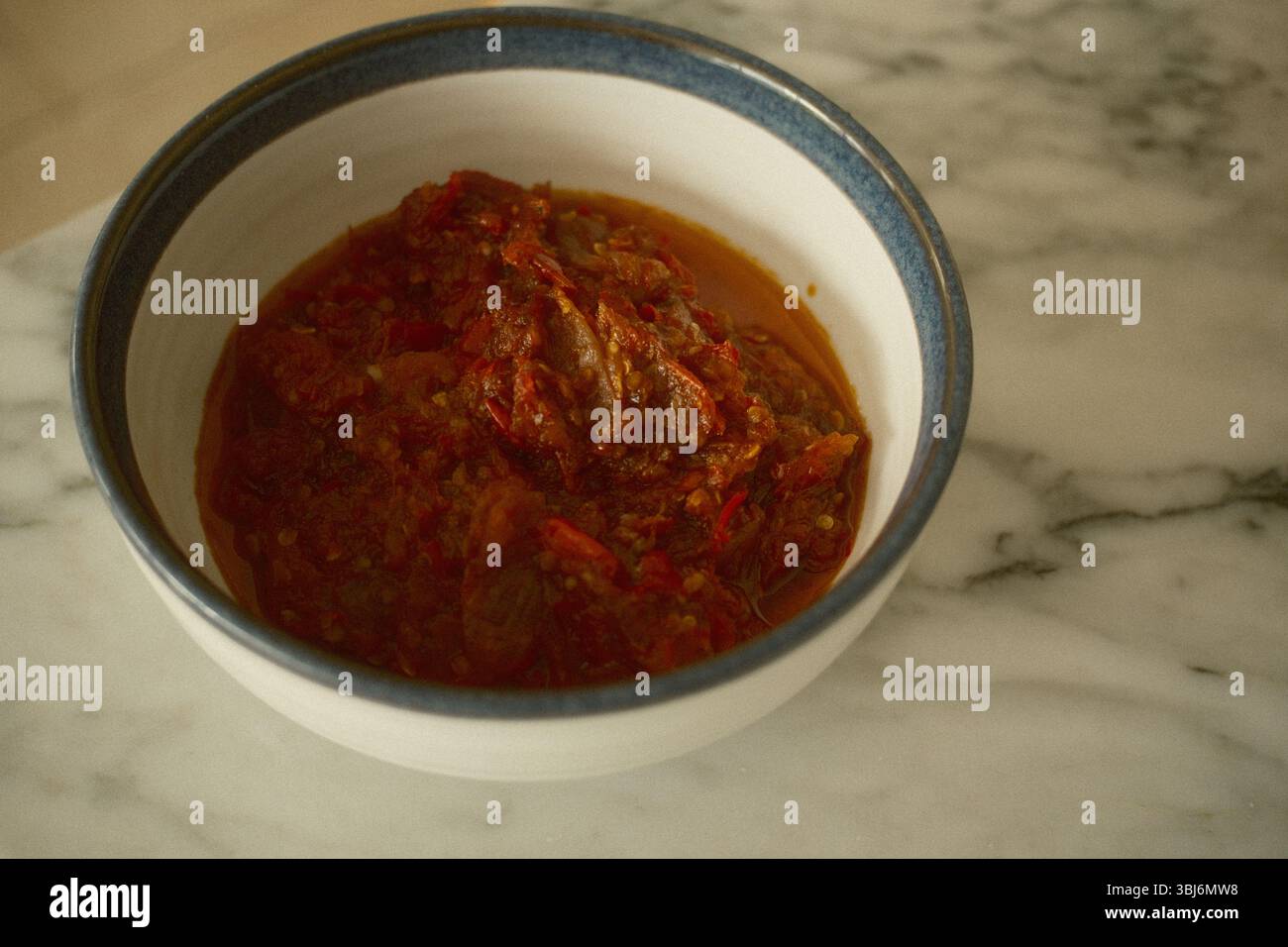 Una ciotola di tradizionale sambal indonesiano, realizzata con peperoncini rossi macinati e spezie Foto Stock