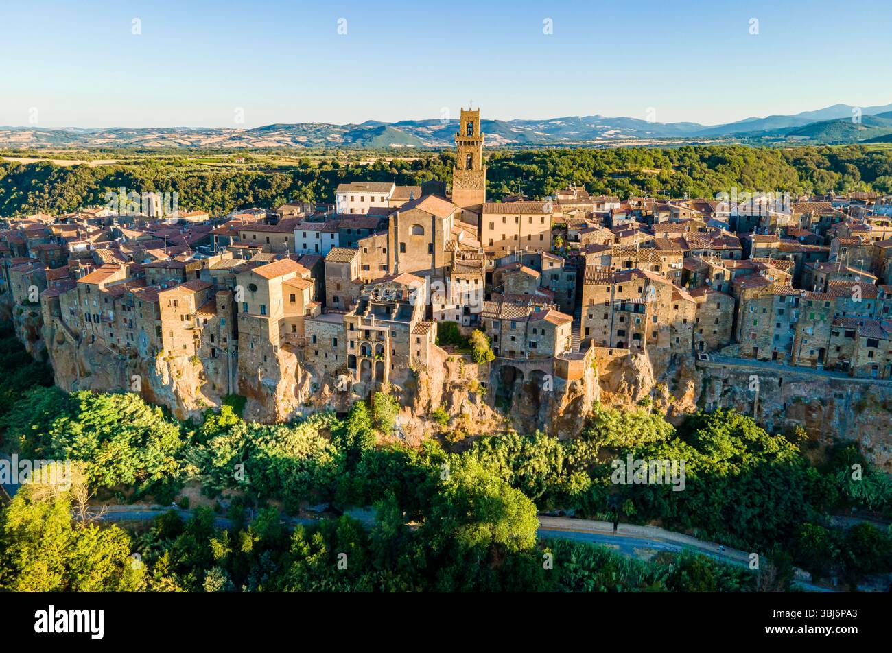 Vista aerea con droni di Pitigliano, Toscana, Italia, con caldi tetti arancioni, tonalità dorate e l'affascinante cittadina collinare nella pittoresca regione vinicola. Foto Stock