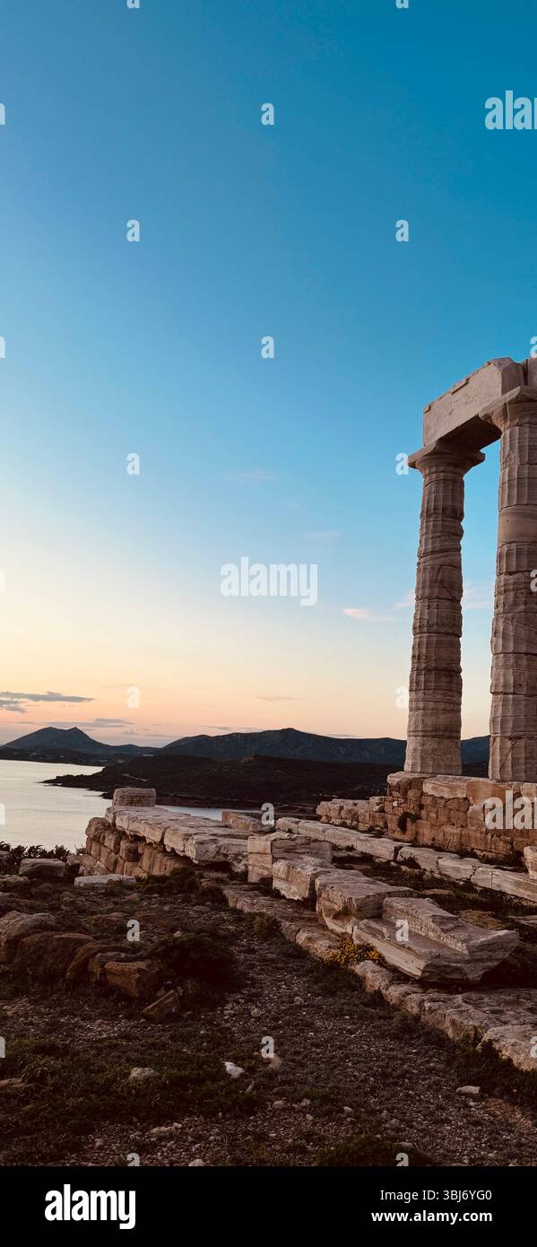 Tempio di Poseidone a Capo Sunio, Grecia, al tramonto. Antiche rovine sul mare con cielo limpido e vista panoramica. - Immagine stock catturata con smartphone