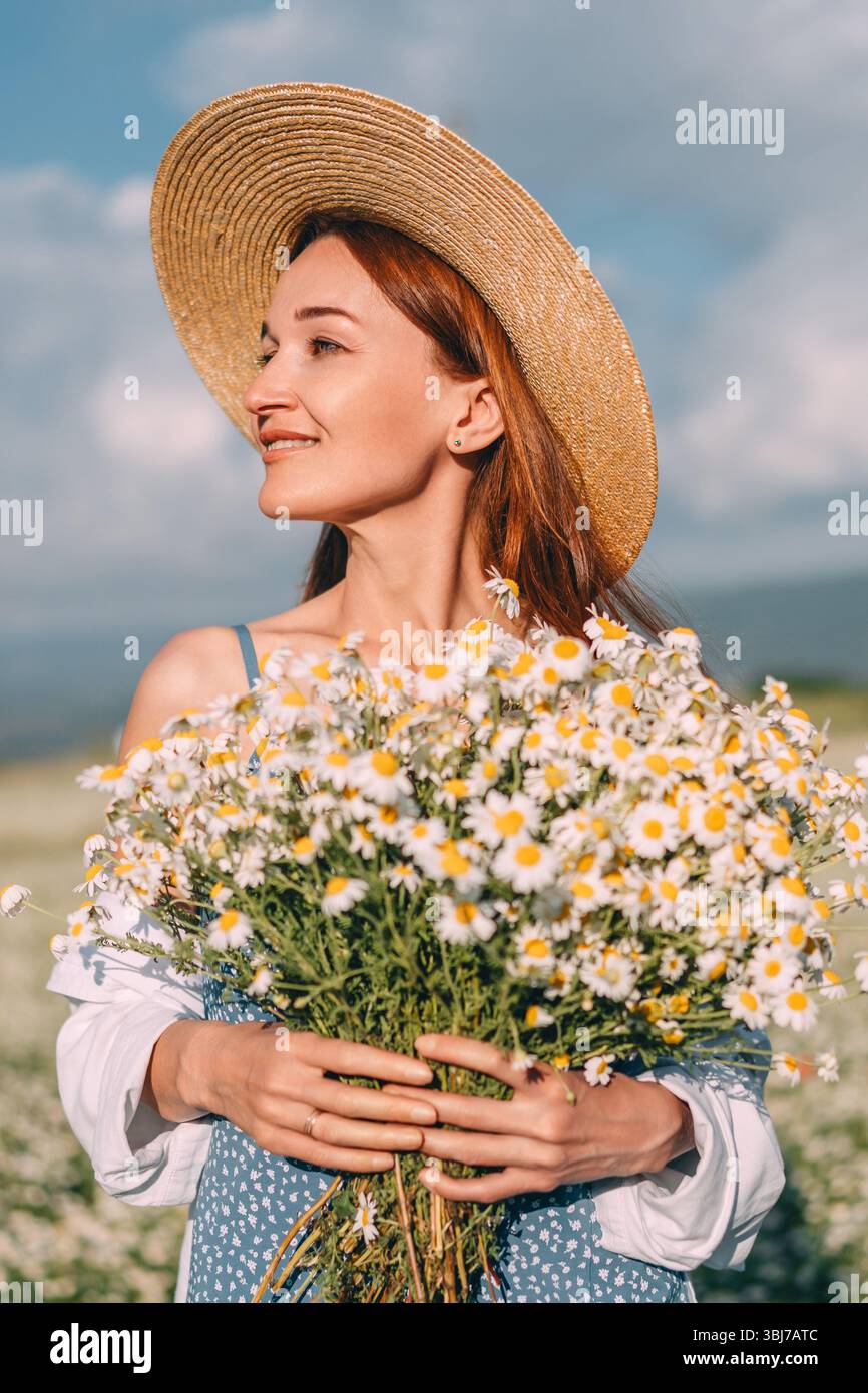 Daisy Flowers Woman Summer Sky. La ragazza tiene il bouquet in un campo a margherita nelle giornate di sole. Foto Stock
