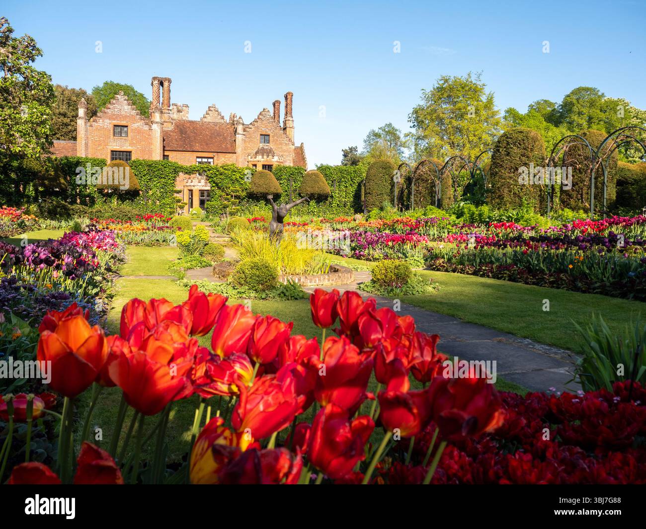 Chenies Manor e giardino sommerso all'ora dei tulipani. Foto Stock