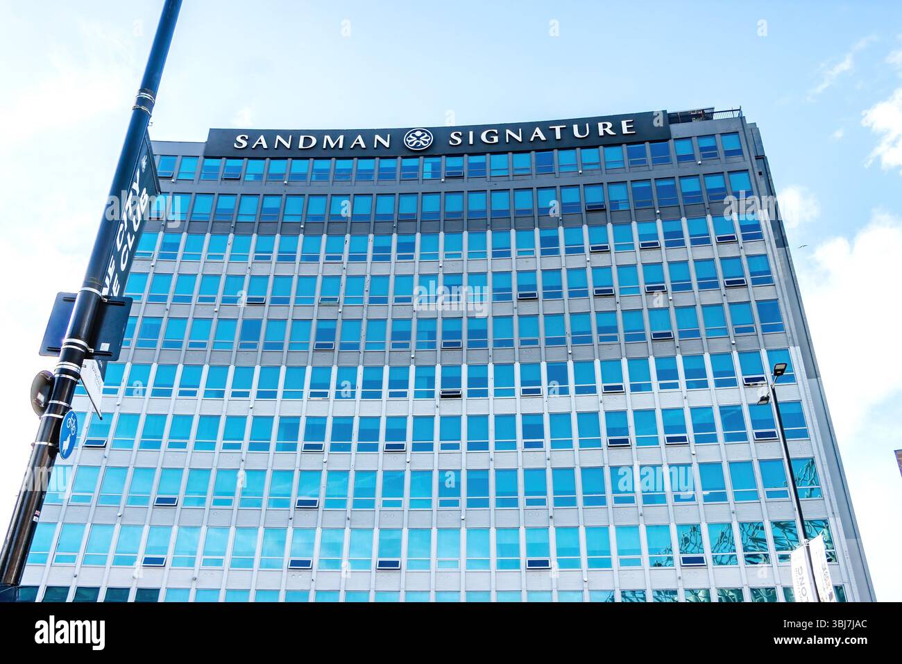 Moderna facciata in vetro del Sandman Signature Hotel sotto un cielo azzurro e limpido in un ambiente urbano di newcastle upon tyne Foto Stock