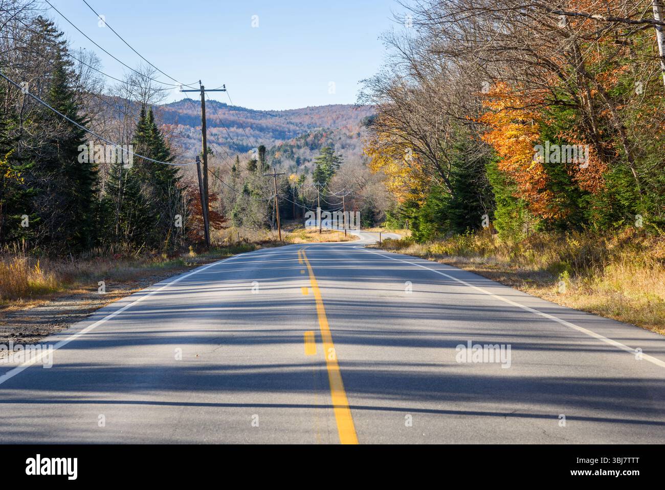 Strada tortuosa vuota nelle montagne al tramonto in autunno Foto Stock