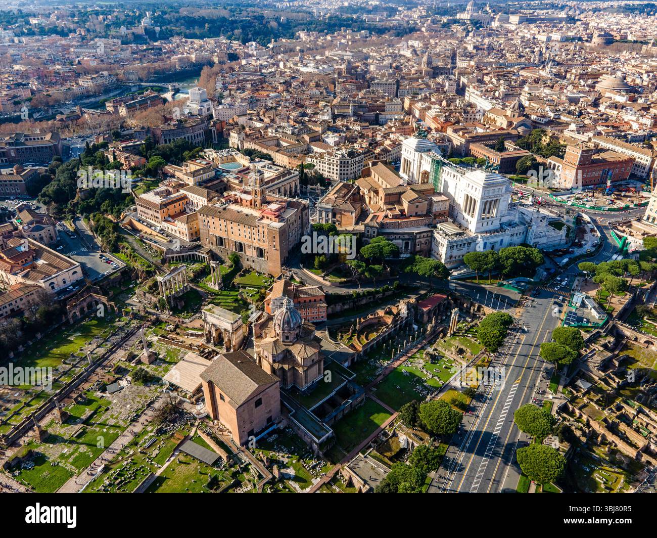 Foto aerea di Roma, Italia, che mostra i monumenti storici della città, i tetti e le antiche strade immerse nella calda luce del sole del Mediterraneo. Foto Stock