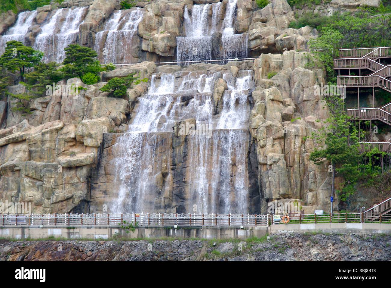 Incheon, Corea del Sud - 19 maggio 2025: Uno sguardo dettagliato alle cascate di Ara, dove terrazze rocciose progettate guidano diversi ruscelli di acqua in caduta accanto a un se Foto Stock