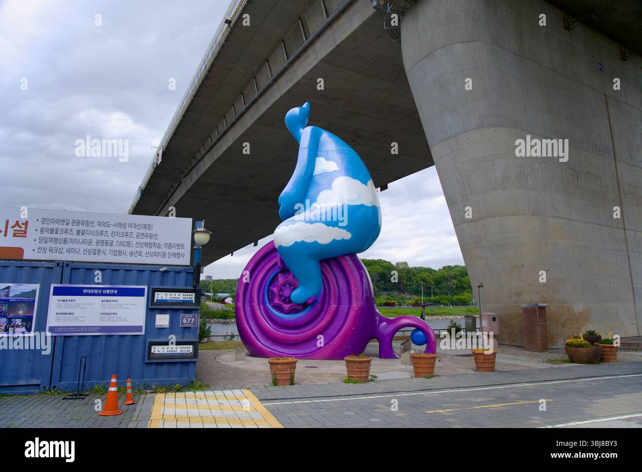 Incheon, Corea del Sud - 19 maggio 2025: Una scultura stravagante conosciuta come Cycling Cloud Man si trova sotto il Sicheon Bridge nel Sicheon Waterside Park, mescolando Foto Stock