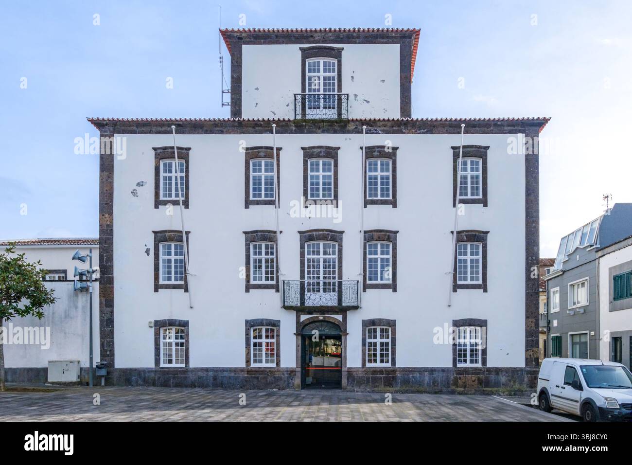 Grande edificio storico delle Azzorre con facciata simmetrica. Architettura tradizionale portoghese, pareti bianche, dettagli in pietra, piazza urbana a Ponta Delgad Foto Stock