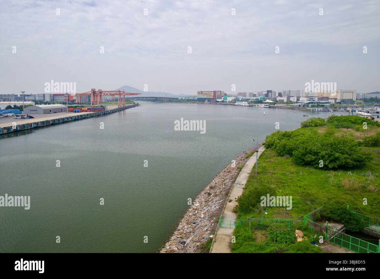 Incheon, Corea del Sud - 19 maggio 2025: Guardando a est dal ponte Jeonho attraverso il canale Ara, con Ara Marina, il terminal passeggeri Ara Gimpo, e. Foto Stock