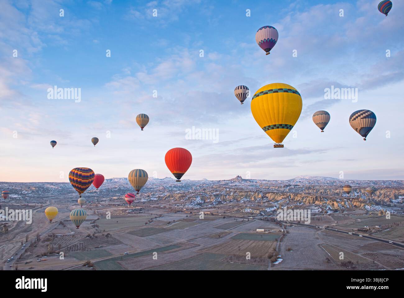 Vista panoramica sulla valle della regione della Cappadocia con camini delle fate e mongolfiere che volano nel cielo Foto Stock