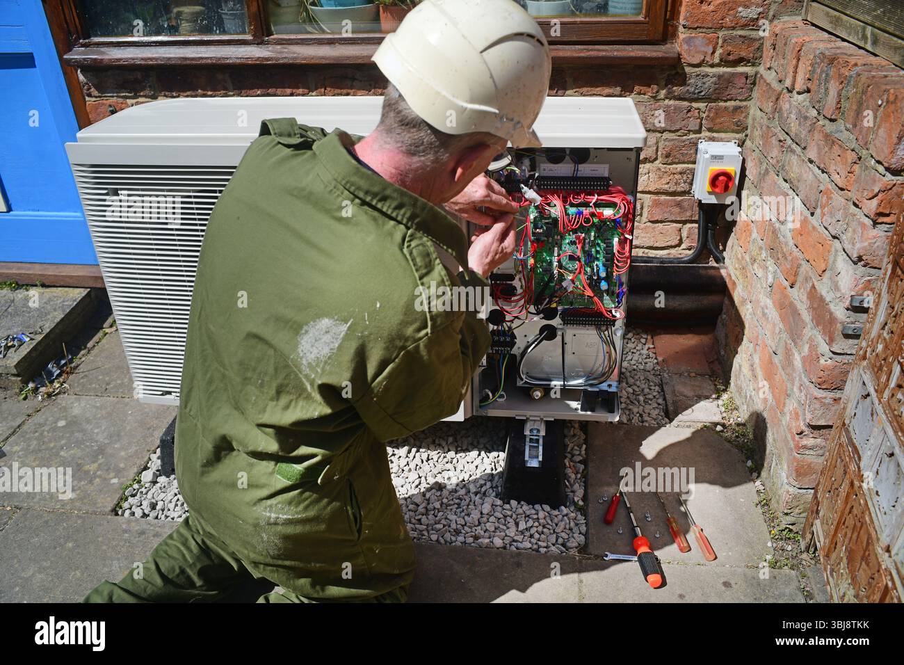 ingegnere che installa la pompa di calore della fonte d'aria regno unito Foto Stock