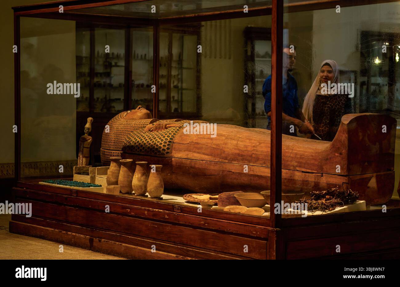Cairo, Egitto - 11 settembre 2023: Un antico sarcofago esposto in un museo circondato da manufatti e visitatori che lo osservano. Foto Stock