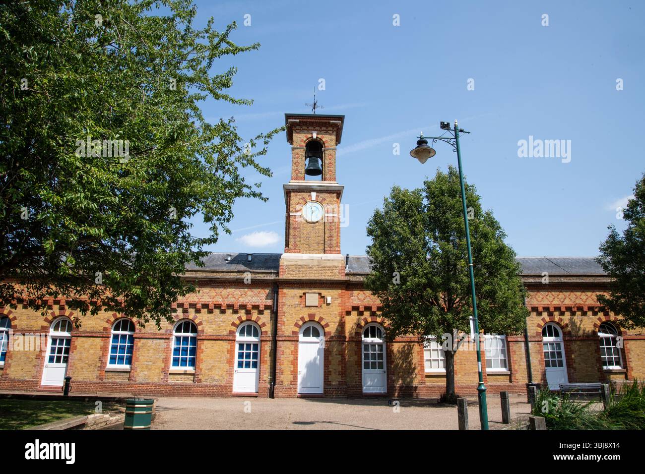 Una vista della torre dell'orologio che si erge in alto accanto al RSA Island Centre nell'Enfield Island Village, che mostra una miscela di storia e moderna spa comunitaria Foto Stock