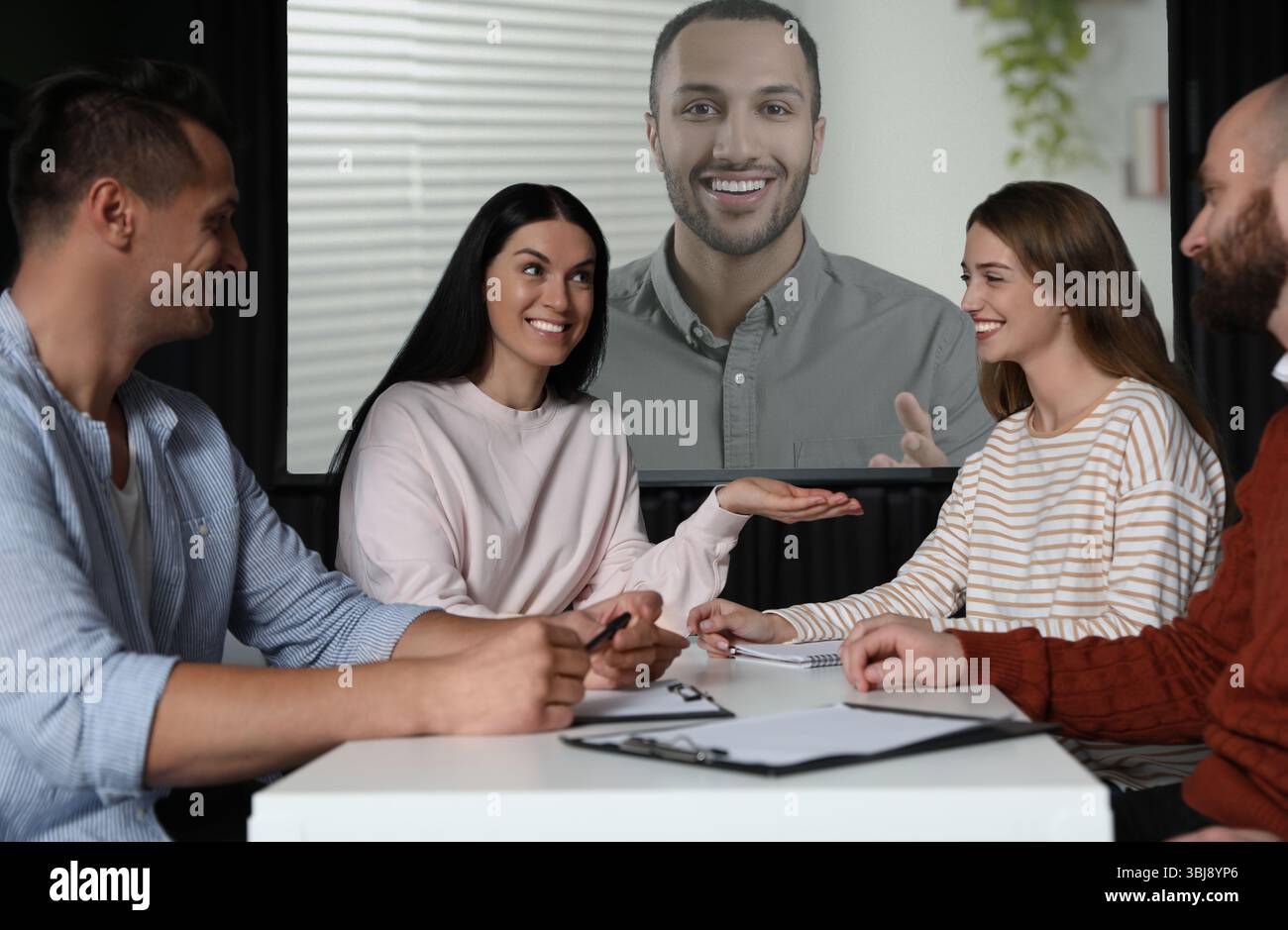 Gruppo di persone che partecipano a una conferenza aziendale al chiuso. Altoparlante sullo schermo di proiezione Foto Stock