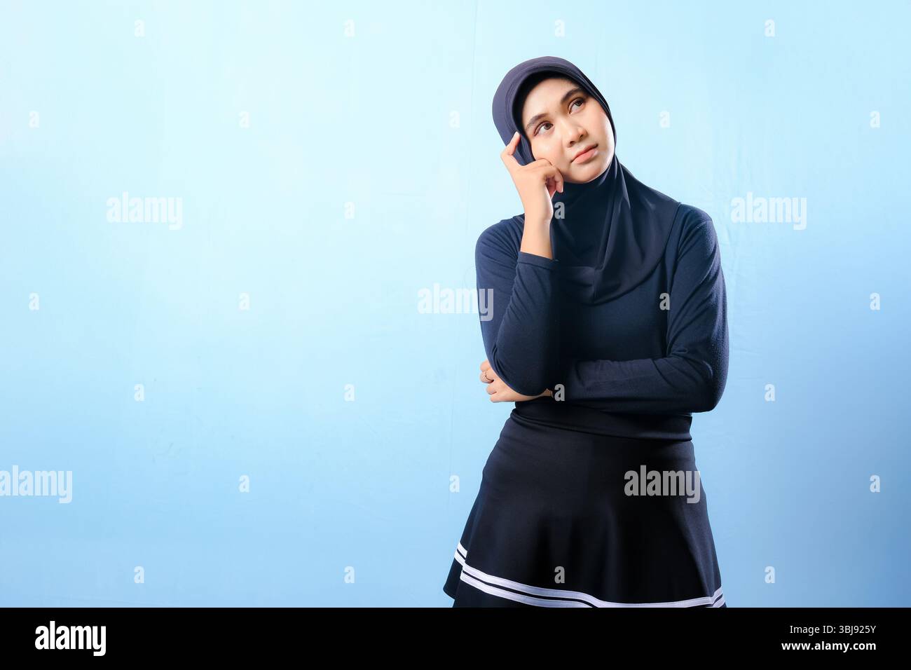 Una donna con una gonna nera e un cappello guarda il cielo. Lei è profondamente pensata Foto Stock