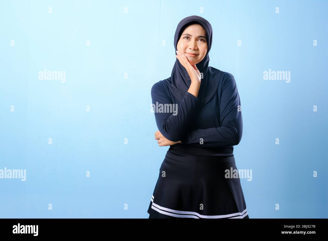 Una donna con una gonna nera e un cappello guarda il cielo. Lei è profondamente pensata Foto Stock