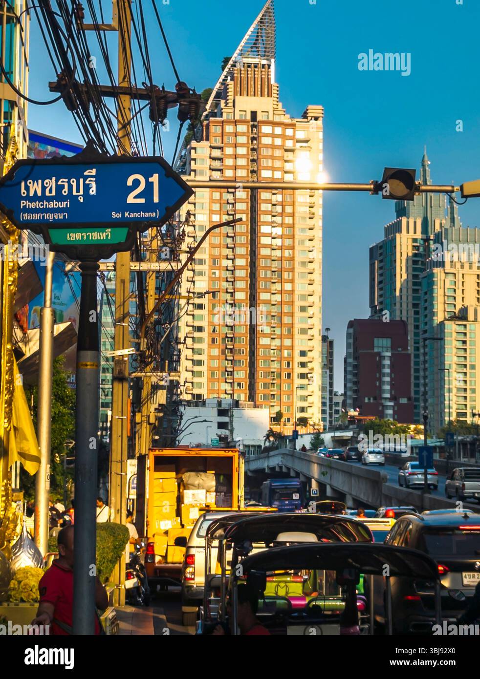 Bangkok, Tailandia, 7 aprile 2024, nel tardo pomeriggio, la luce solare ad angolo basso si riflette casualmente sugli edifici alti e sul traffico intenso sottostante, durante l'ora di punta. Foto Stock
