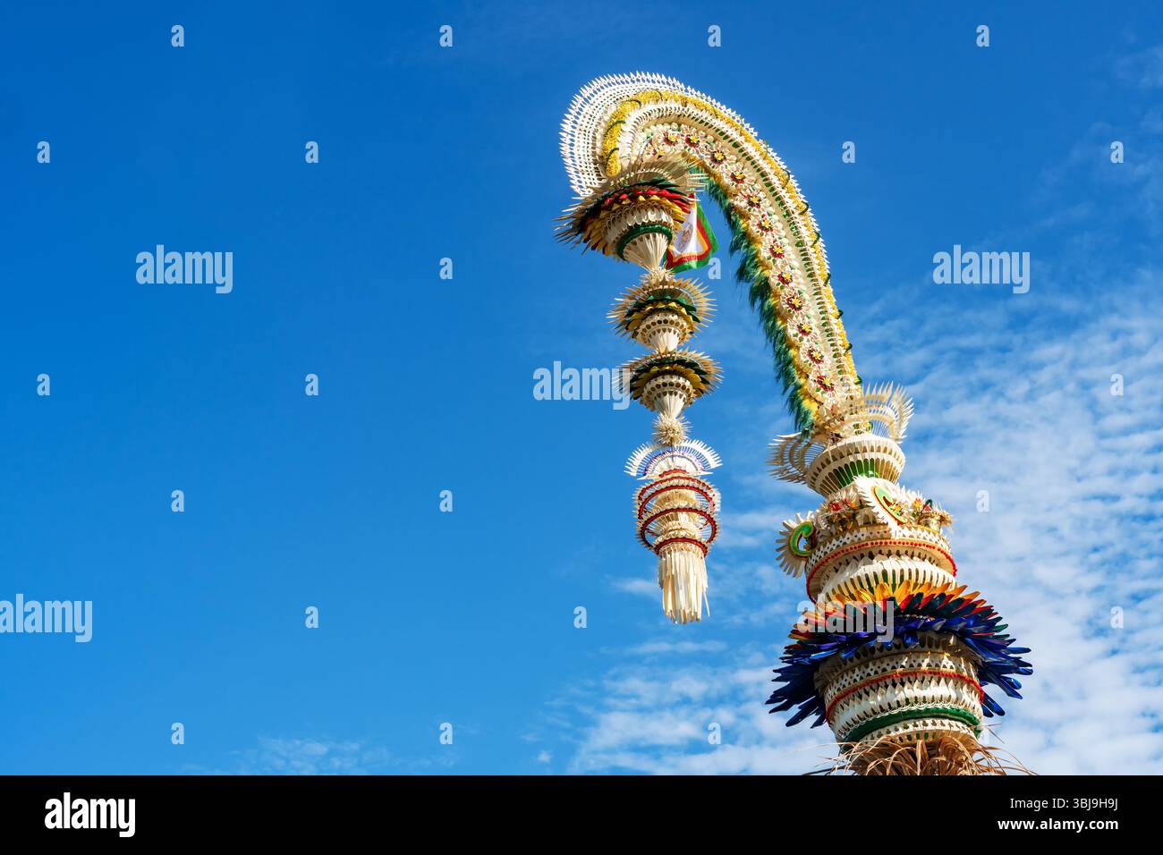 Denpasar, Bali, Indonesia, 16 maggio 2025: Grandi decorazioni Penjor si ergono sul lato della strada nell'area di Denpasar, Bali, con ornamenti realizzati Foto Stock