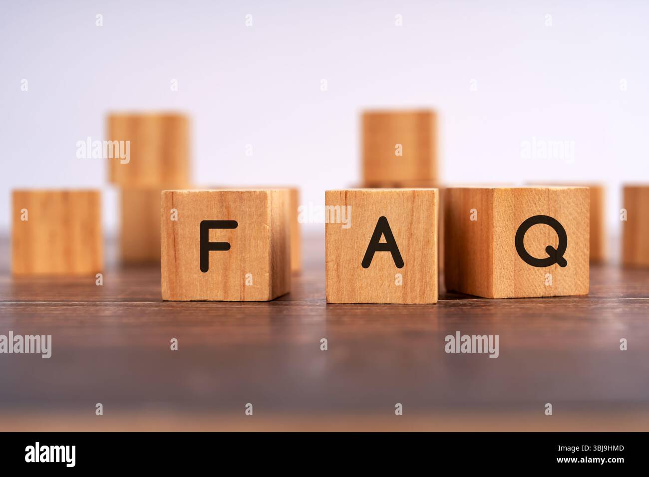 Blocco di legno con FAQ scritte sul tavolo, concetto di domande frequenti, assistenza clienti, assistenza informazioni e assistenza utente Foto Stock