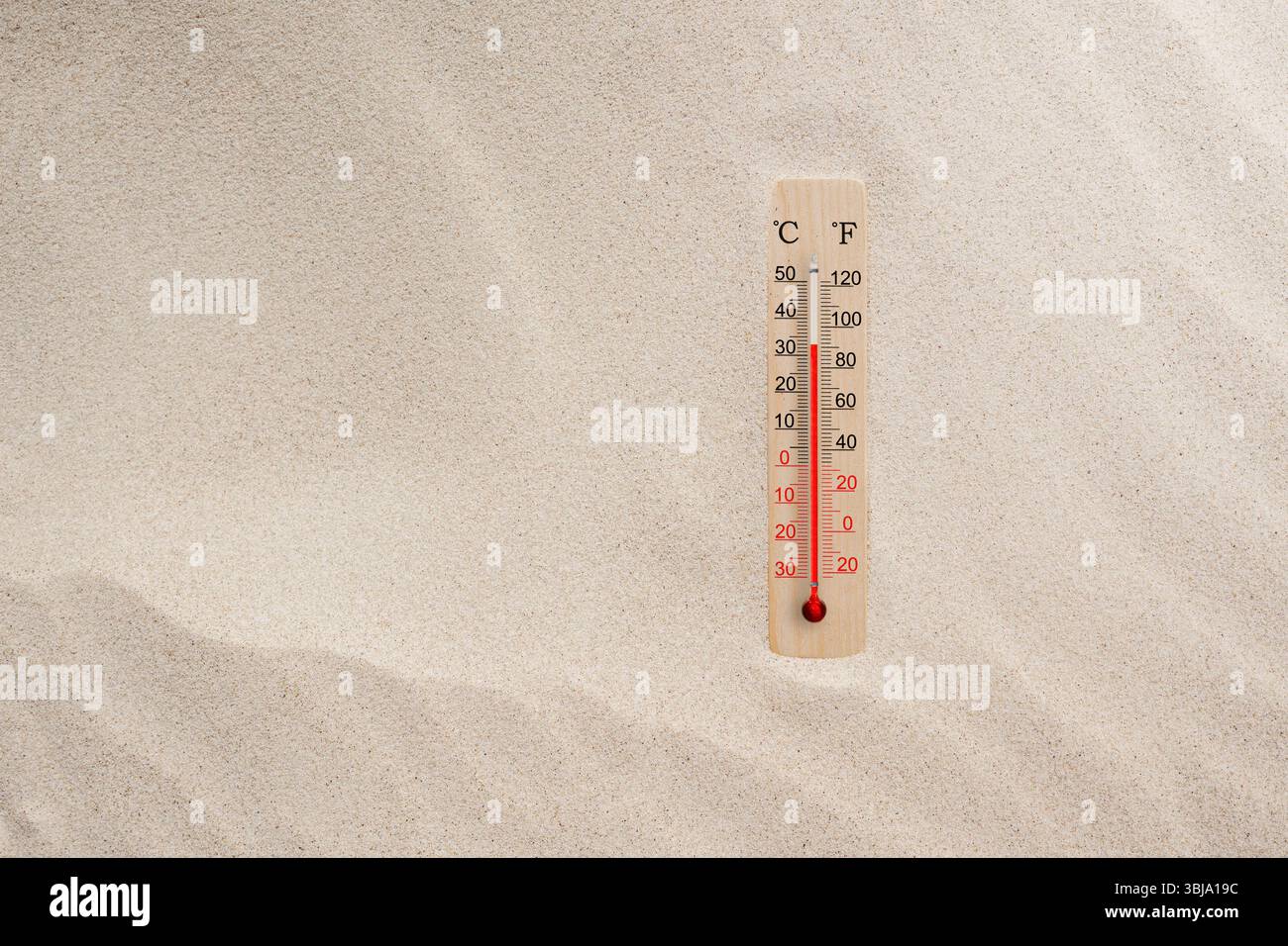 Termometro in legno con scala celsius e fahrenheit nella sabbia. Temperatura ambiente più 33 gradi. Caldo giorno d'estate Foto Stock Termometro in legno con scala celsius e fahrenheit nella sabbia. Temperatura ambiente più 33 gradi. Caldo giorno d'estate Foto Stock