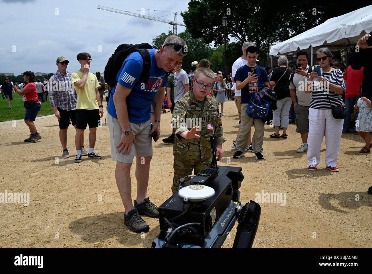 Bradley Kuss e suo padre Kevin Kuss raggiungono un Boston Dynamic Cyber-Dog durante le attività di flag day al National Mall di Washington, DC, sabato 14 giugno 2025. (Foto di Mattie Neretin/Sipa USA) credito: SIPA USA/Alamy Live News Foto Stock