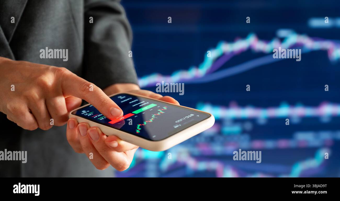 Investitore digitale femminile che analizza le tendenze delle criptovalute su smartphone. Foto Stock