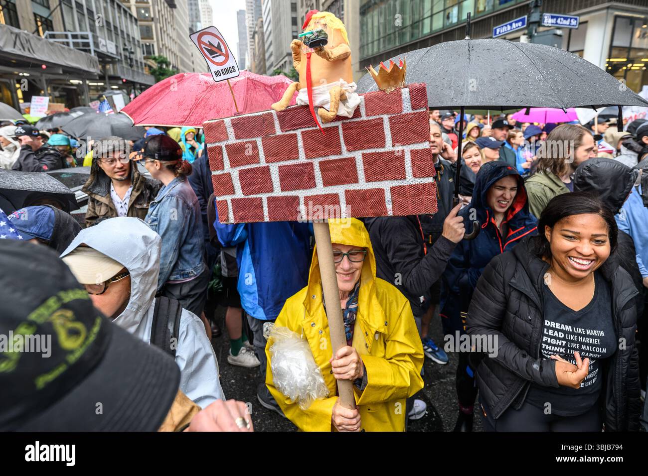 New York, Stati Uniti. 14 giugno 2025. Le persone sfidano la pioggia e portano segni anti-Trump mentre partecipano a una protesta "NO KING” a livello nazionale contro le politiche del presidente degli Stati Uniti Donald Trump. Crediti: Enrique Shore/Alamy Live News Foto Stock