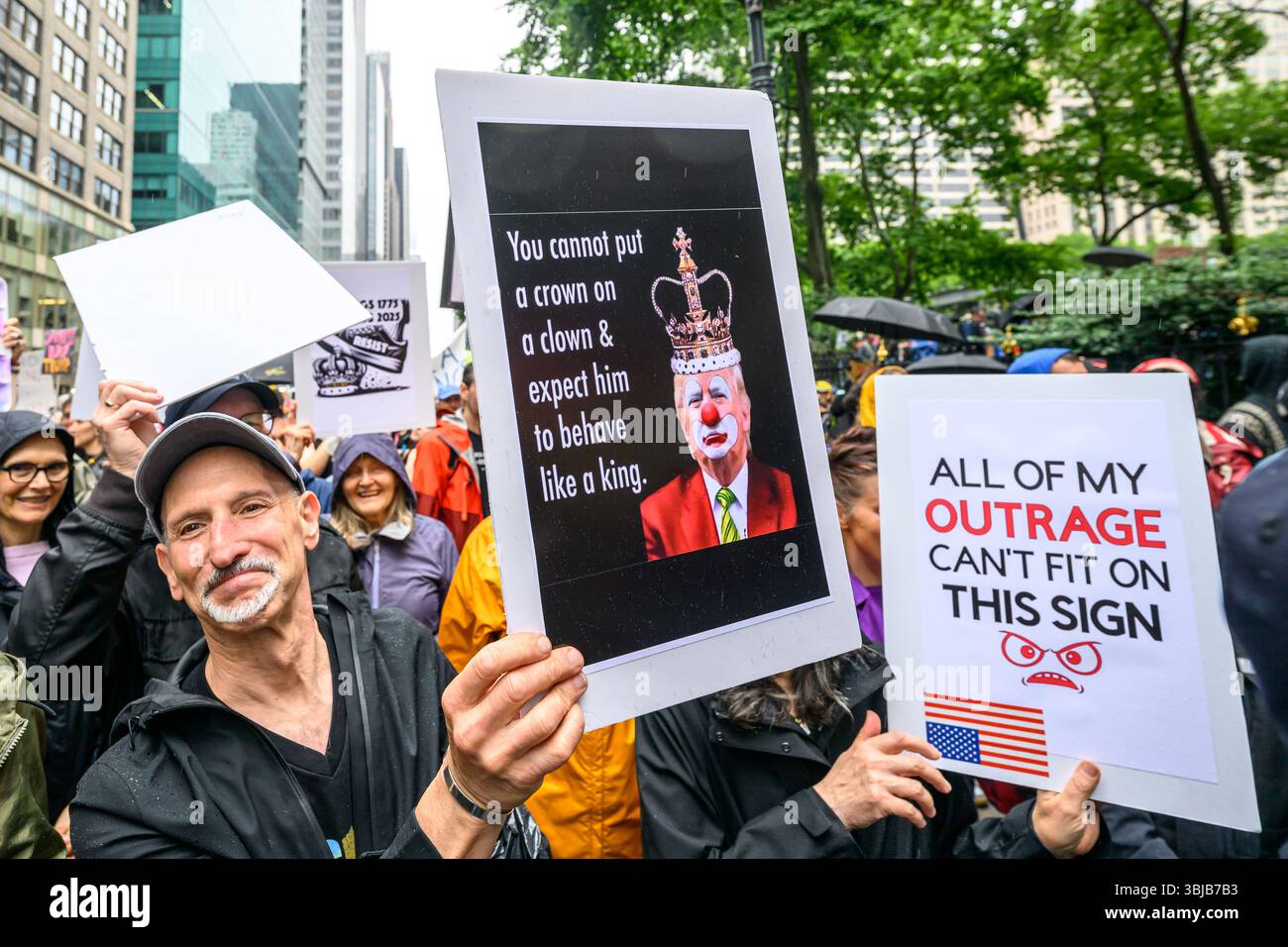 New York, Stati Uniti. 14 giugno 2025. Le persone sfidano la pioggia e portano segni anti-Trump mentre partecipano a una protesta "NO KING” a livello nazionale contro le politiche del presidente degli Stati Uniti Donald Trump. Crediti: Enrique Shore/Alamy Live News Foto Stock