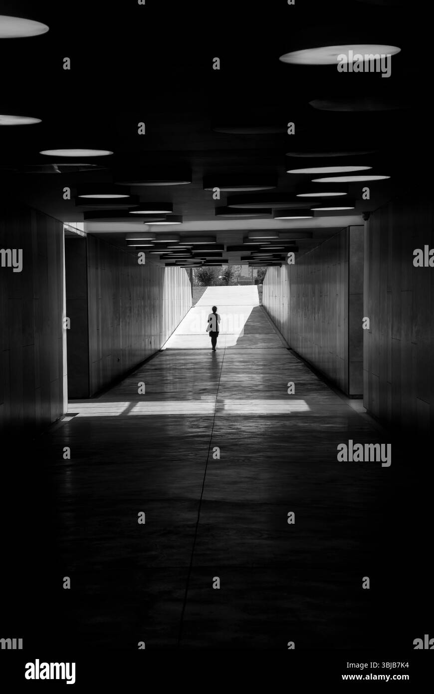 Silhouette nera di una donna in un tunnel Foto Stock