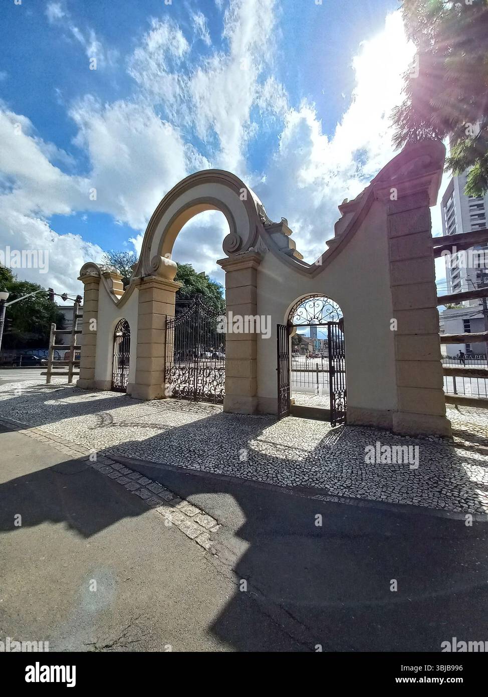 Curitiba Paraná Brasile 3 febbraio 2024 porta ornamentale ad arco di Passeio Público a Curitiba con dettagli in ferro e pavimentazione in pietra sotto il forte sole Foto Stock