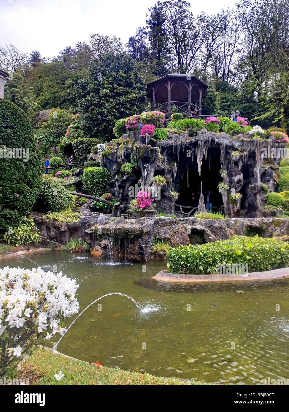 Braga Portogallo marzo 29 2024 lussureggiante grotta con gazebo in legno fiori colorati e cascata al santuario Bom Jesus do Monte Foto Stock