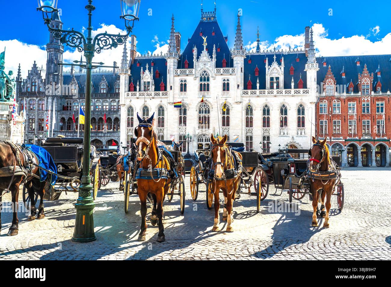 Carrozze trainate da cavalli sulla piazza del mercato nella città vecchia di Bruges, nel centro storico di Bruges, nella regione fiamminga, in Belgio Foto Stock
