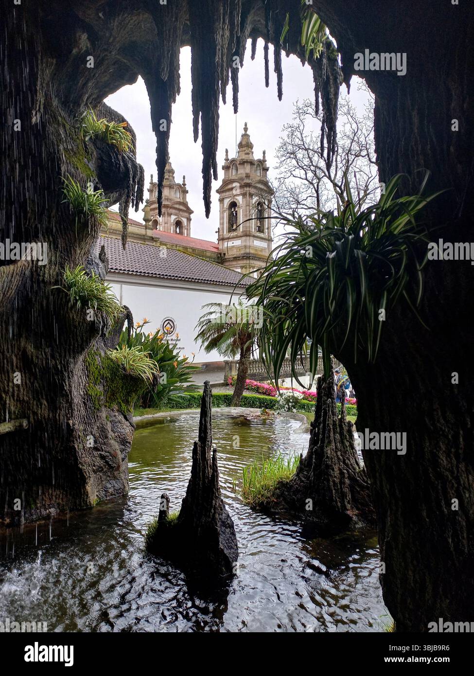 Braga Portogallo marzo 29 2024 lussureggiante grotta con gazebo in legno fiori colorati e cascata al santuario Bom Jesus do Monte Foto Stock