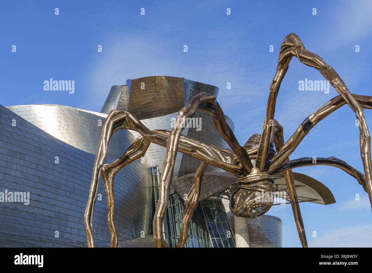 Grande scultura di ragno di fronte a un edificio moderno rivestito in metallo, Bilbao, Paesi Baschi, Spagna, Europa Foto Stock