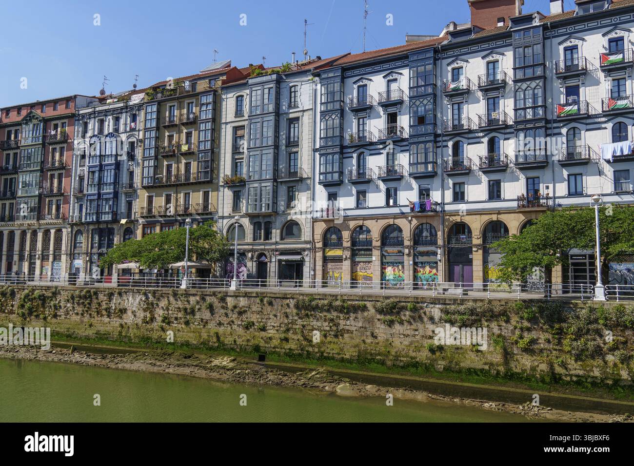 Edifici residenziali situati su un fiume urbano con diversi stili di facciata, Bilbao, Paesi Baschi, Spagna, Europa Foto Stock