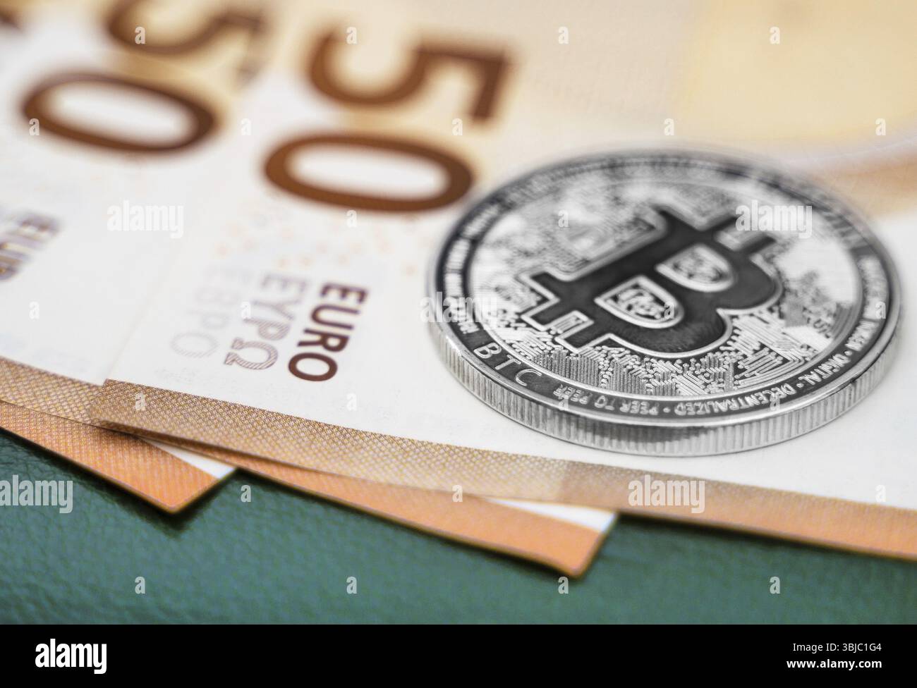Criptovaluta bitcoin d'argento sulle banconote in euro Foto Stock