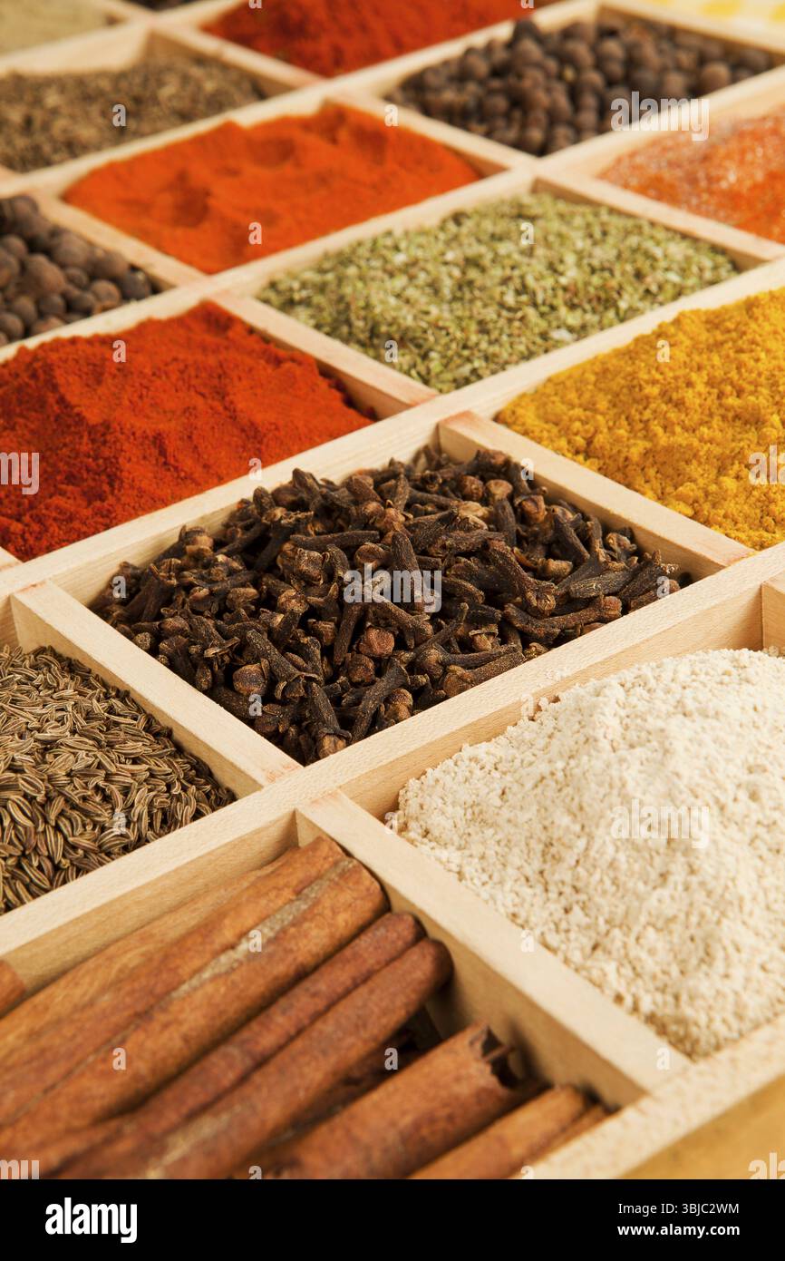 Scatola di legno con erbe e spezie diverse - pepe, paprika, cumino e altri Foto Stock
