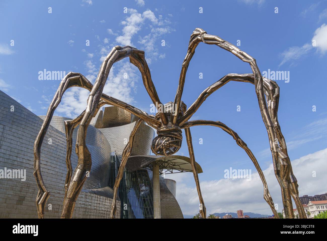 Scultura ragno di fronte a un edificio moderno sotto un cielo parzialmente nuvoloso, Bilbao, Paesi Baschi, Spagna, Europa Foto Stock