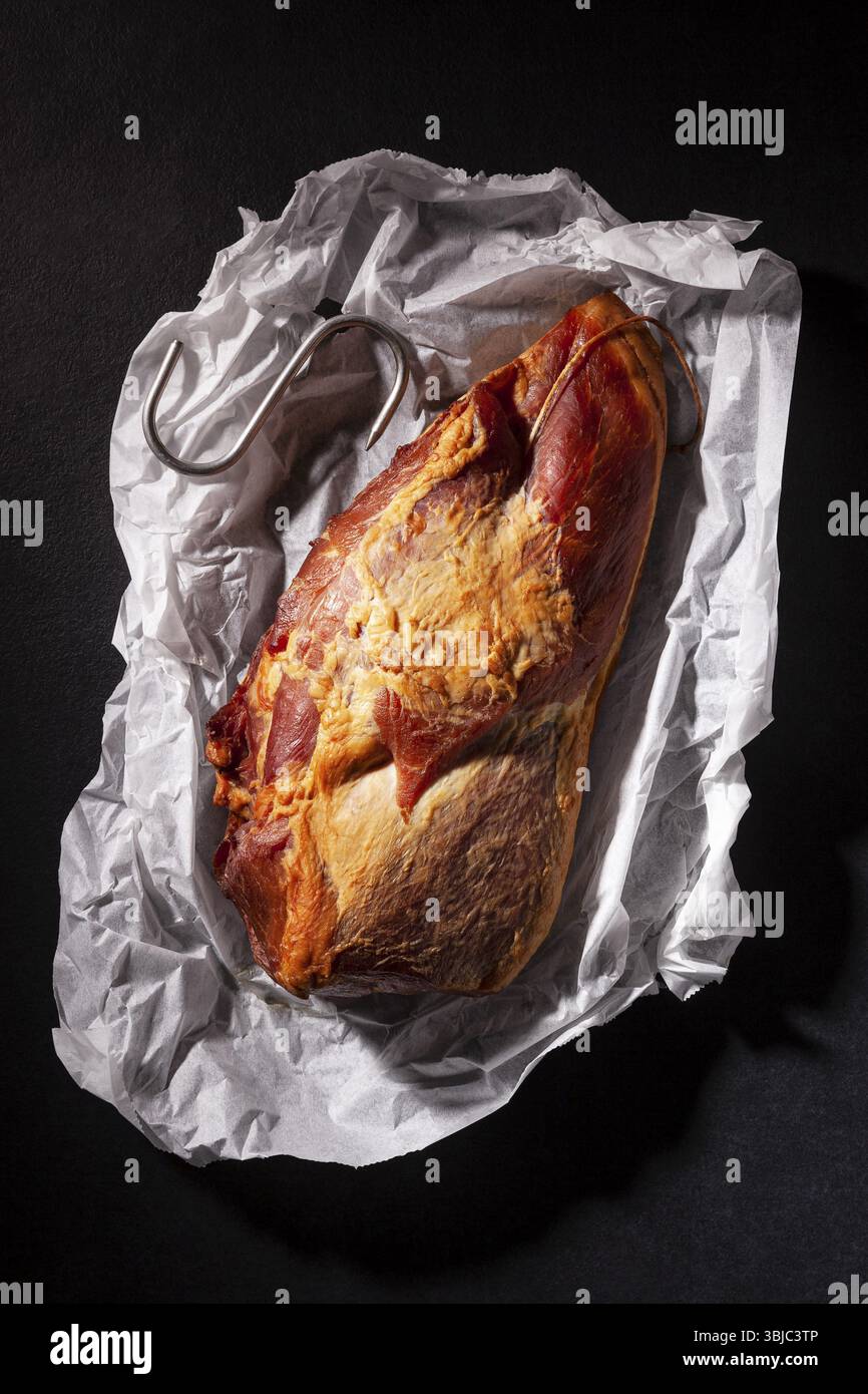 Carne di maiale affumicata su sfondo scuro dall'alto. Cibo gastronomico a base di carne Foto Stock