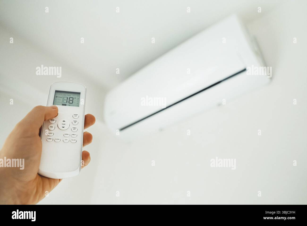 Telecomando con impugnatura rivolta verso il climatizzatore Foto Stock
