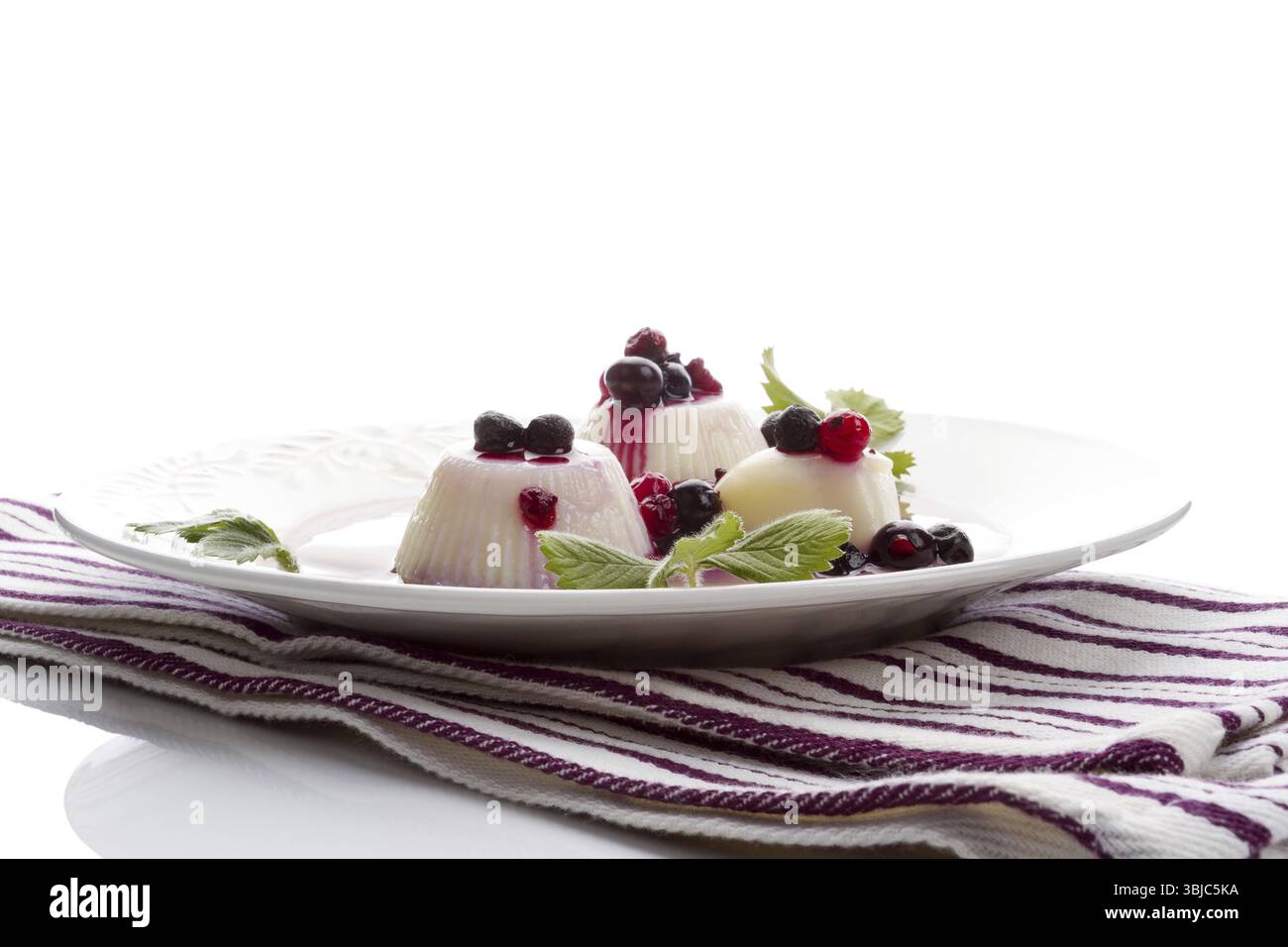 Delizioso budino con frutta fresca su un panno. Concetto di dolci culinari. Isolato su bianco Foto Stock