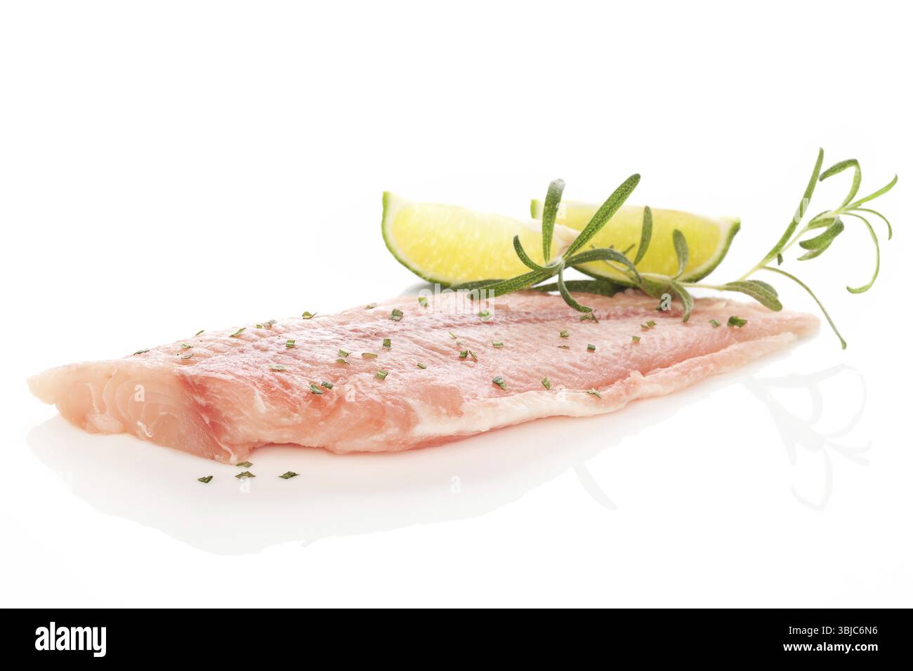 Delizioso filetto di pesce con erbe fresche e calce isolata su sfondo bianco. Cucina a base di pesce Foto Stock