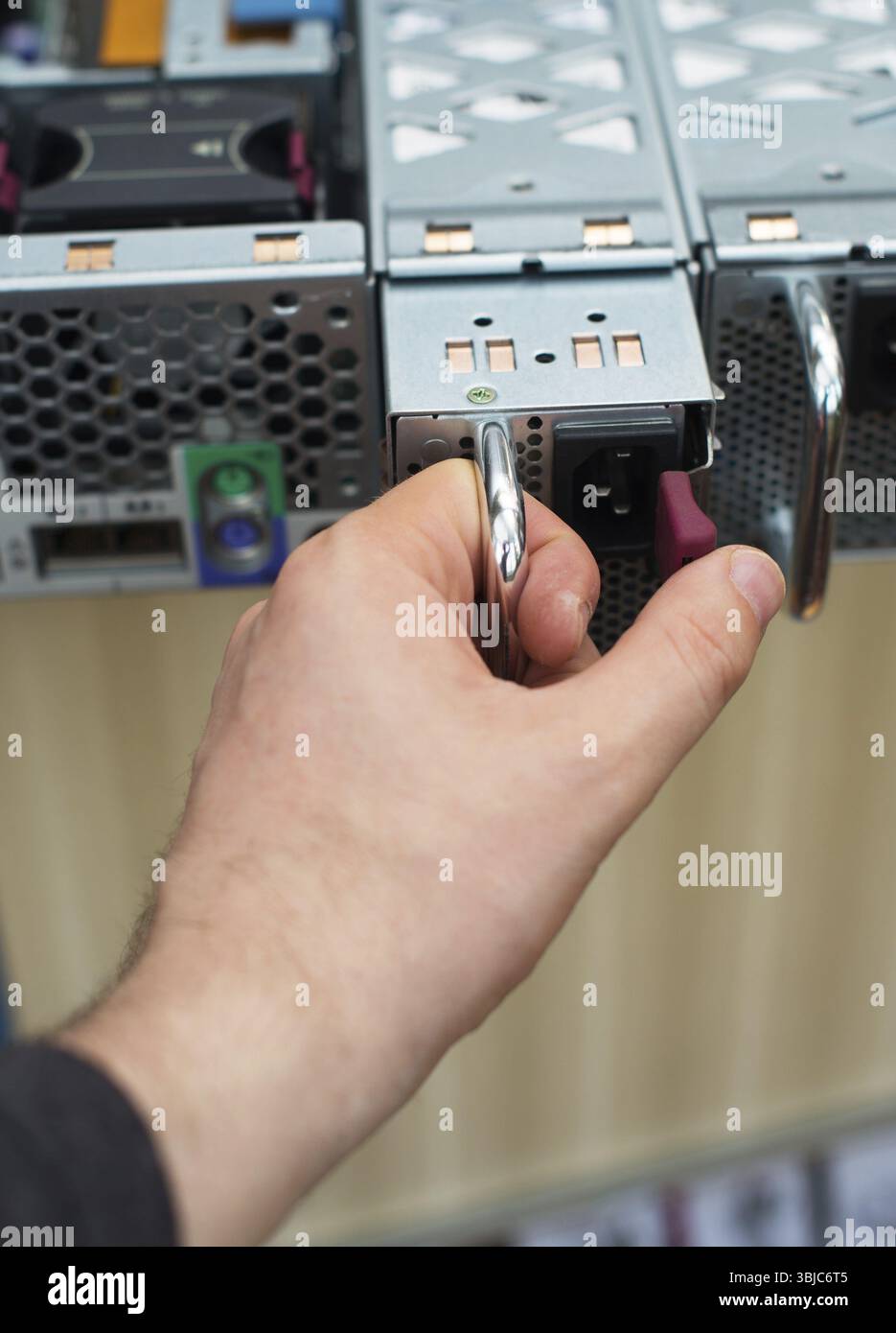 Tecnico informatico che installa l'alimentatore sul server Foto Stock