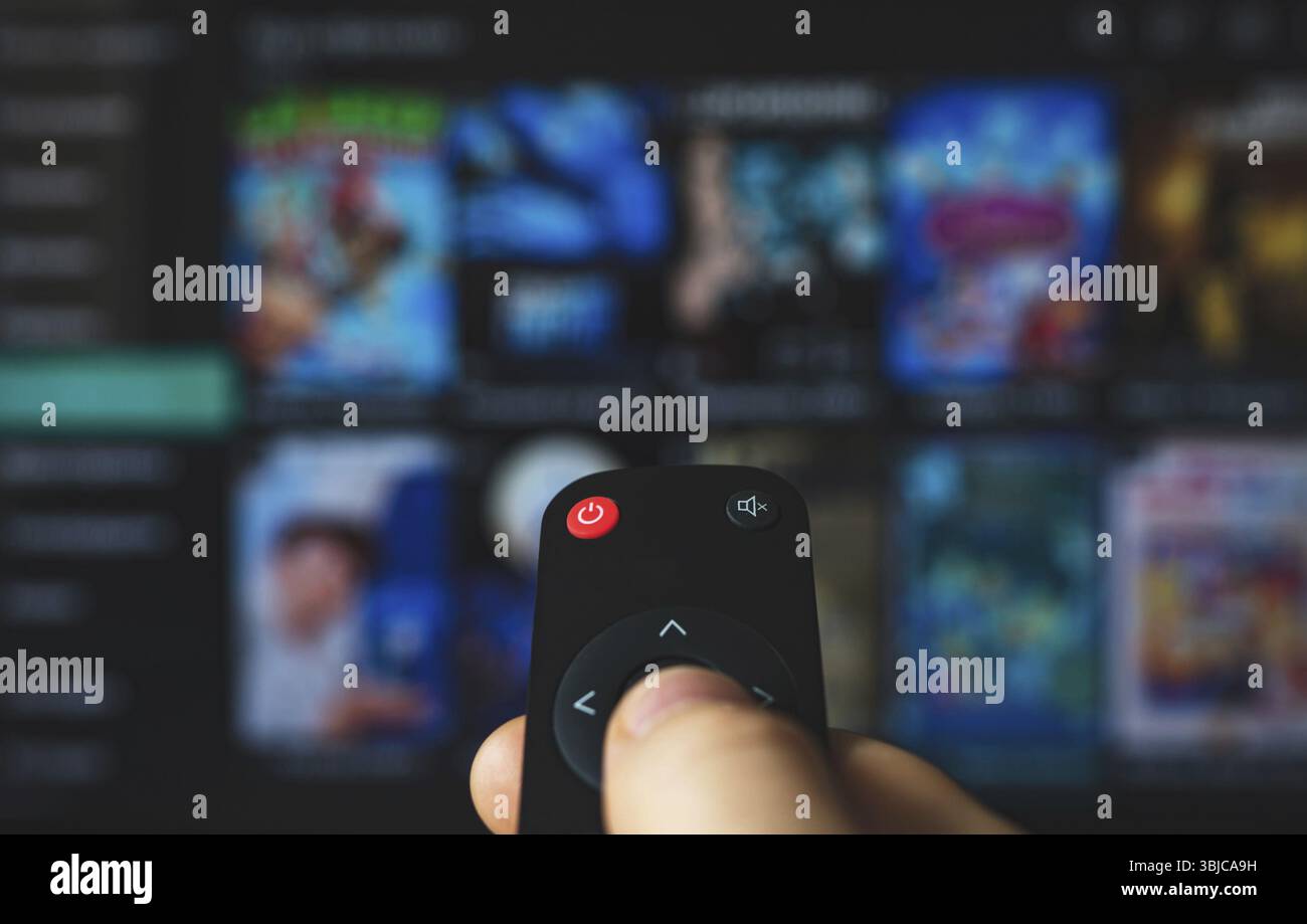 Mano maschile con telecomando che punta su Smart TV Foto Stock